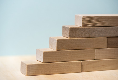 Stairs concept with wooden blocks. Growth and success conception. Blue background.の写真素材