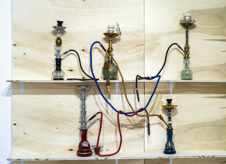 Ancient hookahs on shelf. Various models and colours. Arabic culture Smoking accessories.