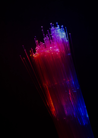 Colourful optic fibers illuminated on dark background. High speed internet concept. Data transfer...