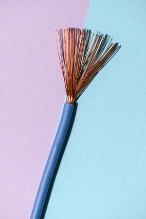 Electrical cable on pink and blue background. Spread out copper wires. Minimalist electrical background.の写真素材