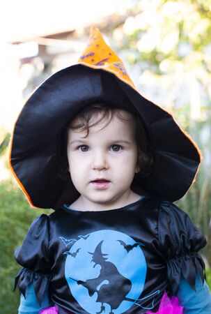 A little girl with a Halloween costume. Black witch hat on head.の写真素材