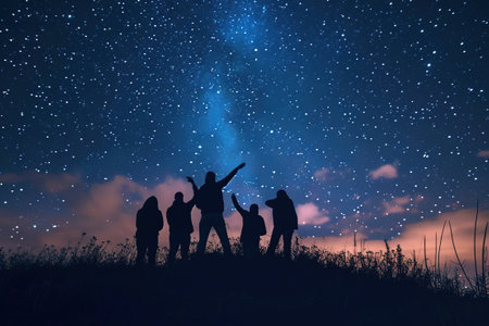 Silhouettes of people stargazing against a night sky.の素材