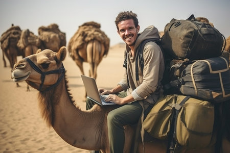 A man programmer riding a camel. Coding sitting on camel with a laptop in the desert. Working remote on computer outdoor.の素材