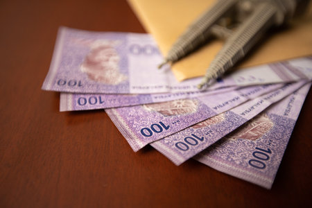 Close up of an envelop filled with documents or contracts with money under it. Venality, bribe,...