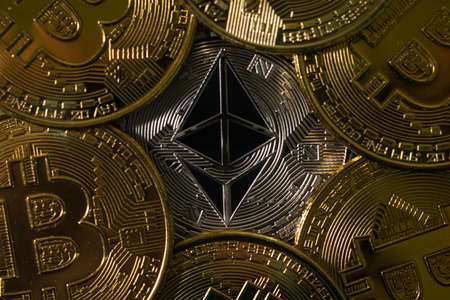 Silver Ethereum token among golden Bitcoin tokens. Digital currency. Cryptocurrencyの写真素材