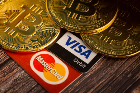 Bayan Lepas, Penang, Malaysia - February 20 2022: Golden Bitcoin with Visa and Mastercard logo token on a wooden background. Digital currency. Cryptocurrency. Bitcoin walletのeditorial素材