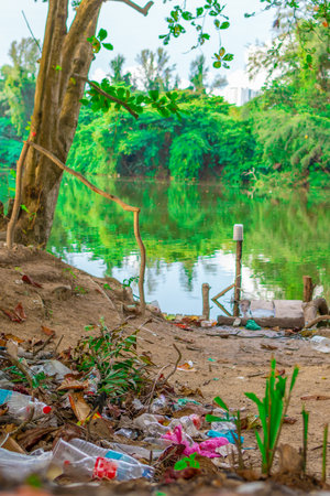 Garbage waste disposal by the lakeside. Environmental Pollution. Global Warming. Save Earthの写真素材