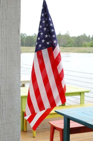 American flag hanging outside at restaurant with tables in background.の写真素材
