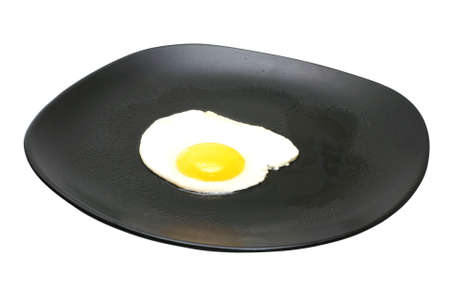 One egg cooked sunny side up on black plate.  