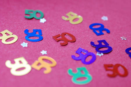 50th birthday party.  Fifties and confetti on pink tablecloth. の写真素材