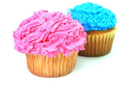 Pink and blue cupcakes with decorative frosting.  Isolated on white background.の写真素材