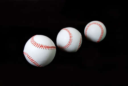 Three baseballs isolated on black background.の写真素材