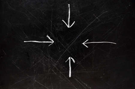 Arrows on black chalkboard pointing to center.  の写真素材
