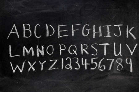 Alphabet and numerals on black chalkboard with copy space.  の写真素材