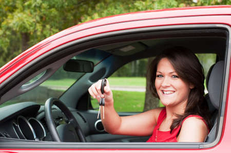 Girl sitting in car and holding keys. の写真素材
