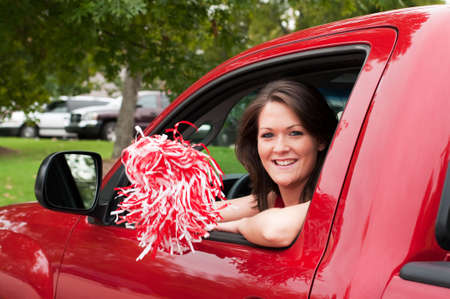 Girl sitting in truck and shaking pom pom.  の写真素材