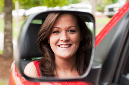 Female portrait of attractive brunette in vehicle mirror.  の写真素材