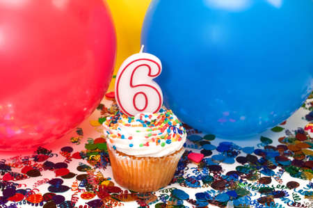 Celebration with balloons, confetti, cupcake, and number 6 candle.の写真素材