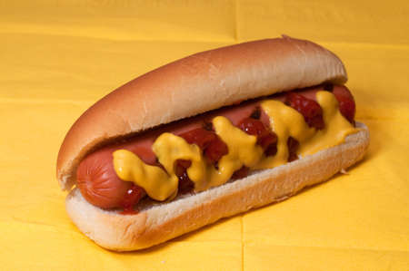 Hot dog with ketchup and mustard on yellow napkin.の写真素材