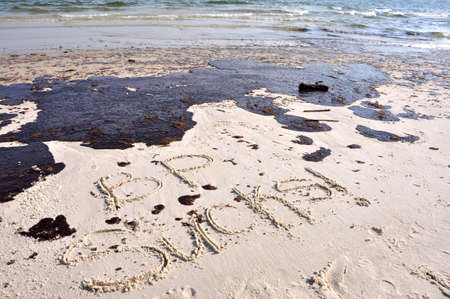 BP oil spill on Gulf of Mexico beach.  "BP SUCKS" Written in sand.のeditorial素材