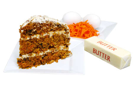 Slice of carrot cake on white plate with ingredients in background. Isolated on white background with clipping path.の写真素材