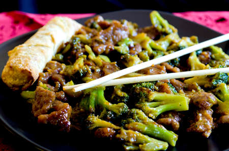 Beef with broccoli with spring roll and chop sticks の写真素材