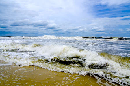 Tropical storm waves crashing on the coast with storm clouds above.の写真素材