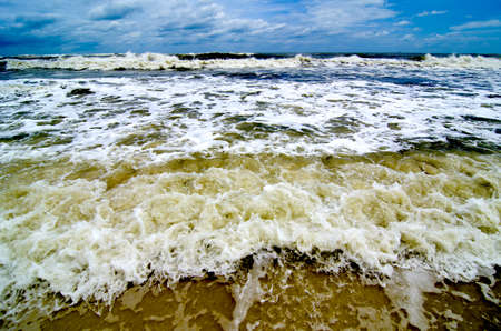 Tropical storm waves crashing on the coast with storm clouds above.の写真素材