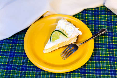 Slice of key lime pie with fork overhead.の写真素材