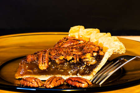 Pecan pie closeup with fork on plate.の写真素材
