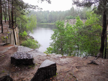 Abandoned flooded quarry in the forest. Lake in the forest. Geological outcrops.の写真素材