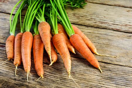 Bunch of fresh and sweet carrot on a old wooden table.の写真素材
