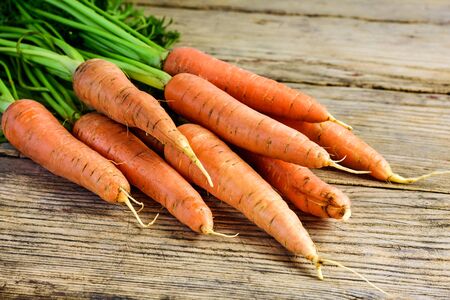 Bunch of fresh and sweet carrot on a old wooden table.の写真素材