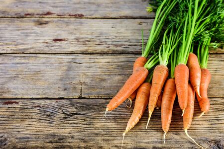 Bunch of fresh and sweet carrot on a old wooden table with copy space for text.の写真素材