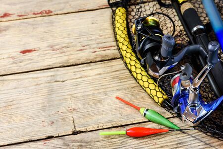 Fishing rods and reels with line on wooden background with free space for text.の写真素材