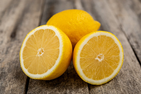 Fresh lemon cut in half on rustic wooden table.の写真素材