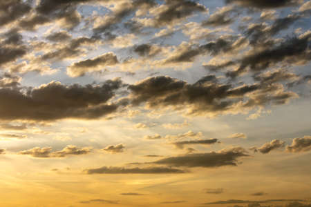 Background of the dramatic sky with dark clouds at sunset.の写真素材