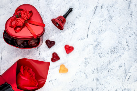 Heart-shaped gummy candies with a metal gift box, red rose and bell for Valentine's Day or Women's Day. Top view.の写真素材