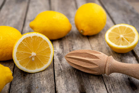 Fresh lemons and wooden juicer on rustic table. Selective focus.の写真素材