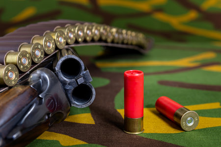 Hunting rifle with ammunition lying on a camouflage background. Selective focus.の写真素材