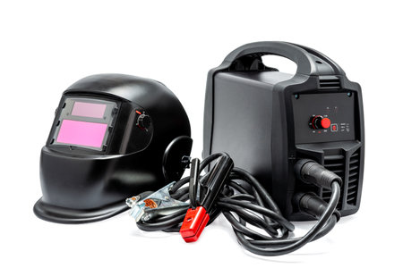 Black inverter welding machine with high-voltage wires and clamps and welding mask isolated on white background.の写真素材