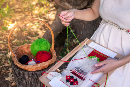 Woman weaver's hands using a weaving needle on a hand loom. Selective focus.の写真素材