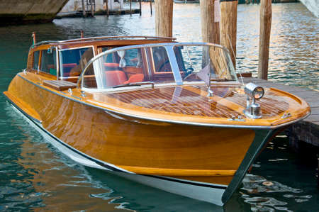 VENICE, ITALY - AUGUST 11, 2012: Wooden motorboat photographed in Venice channels.のeditorial素材