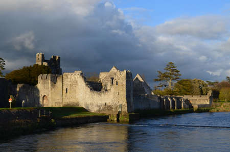 Sun shining through the storm clouds on Desmond Castle in Ireland.