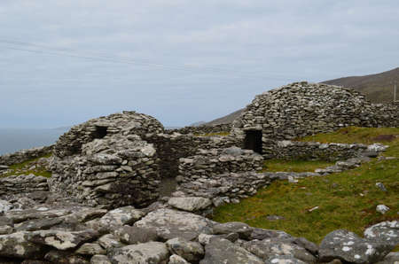 Collection of stone beehive huts in a village.