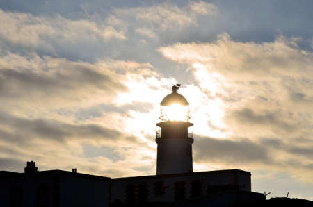 Sun shining through the lighthouse at Neist Point in Scotland.の写真素材