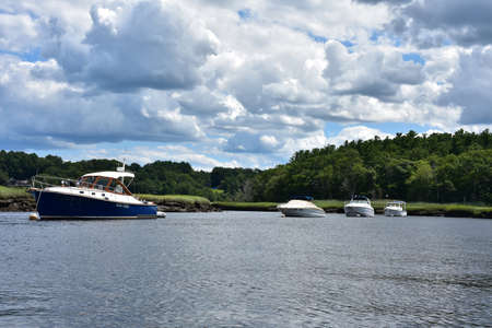 Lot of boats anchored in a tidal river in the springtime.の写真素材