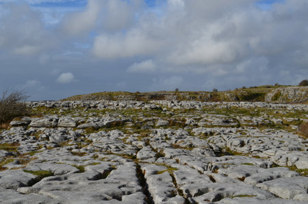 Stunning landscae of gray stones in burren with a cloudy blue sky