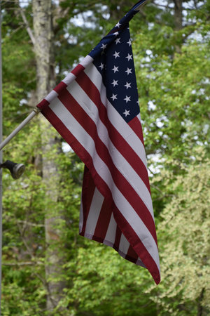 Patriotic stars and stripes flag hanging on a pole.