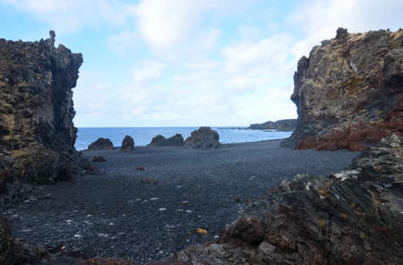 Icelandic black lava rock cliffs on black sand beach.の写真素材